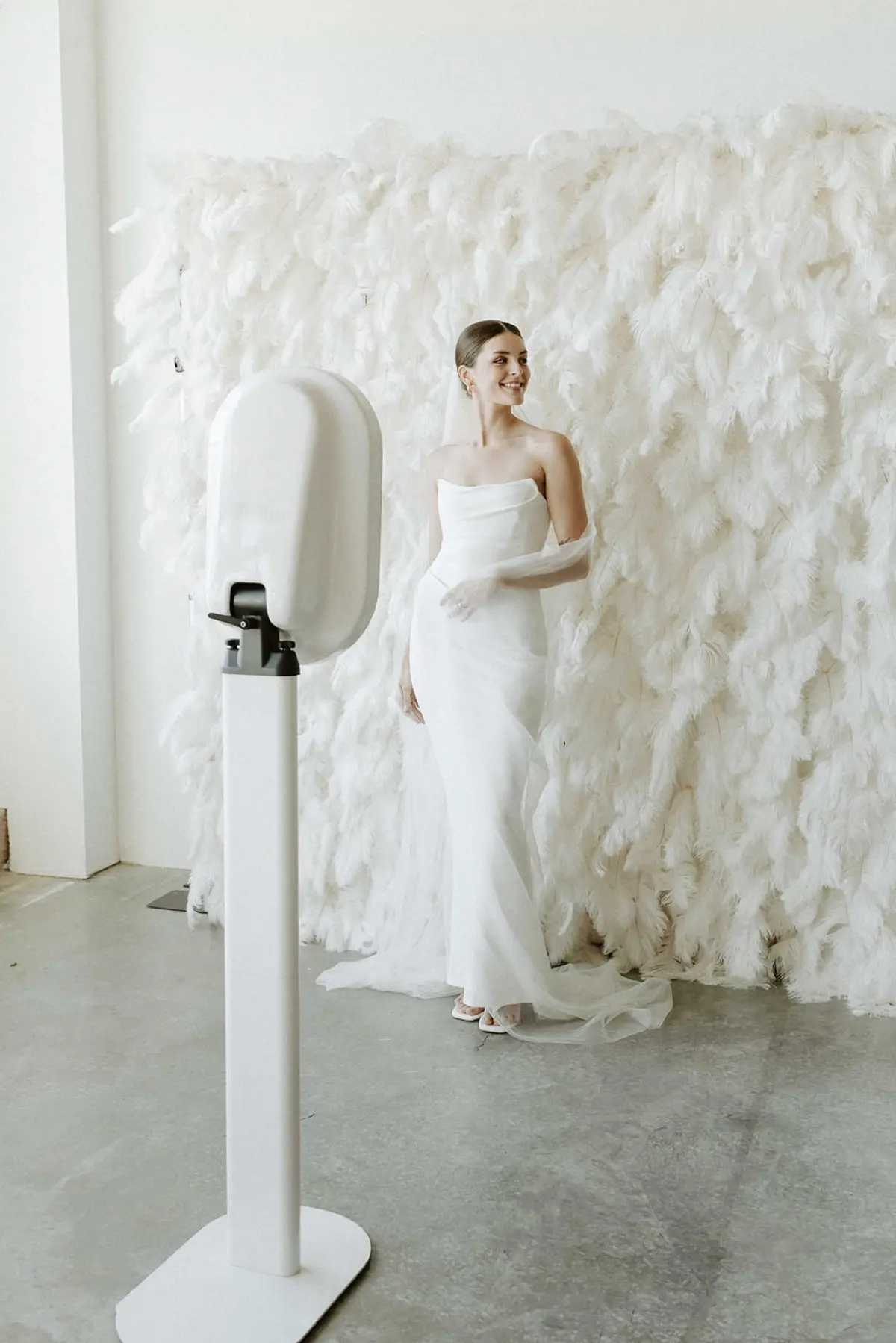Quinceañera photo booth with feather and flower wall backdrop in Los Angeles
