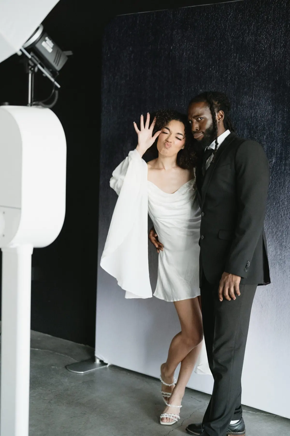 Wedding guests enjoying photo booth with toast dark backdrop in Los Angeles